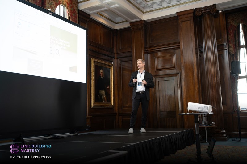 Jesper Nissen presenting on stage at the Link Building Mastery conference in London, 2025